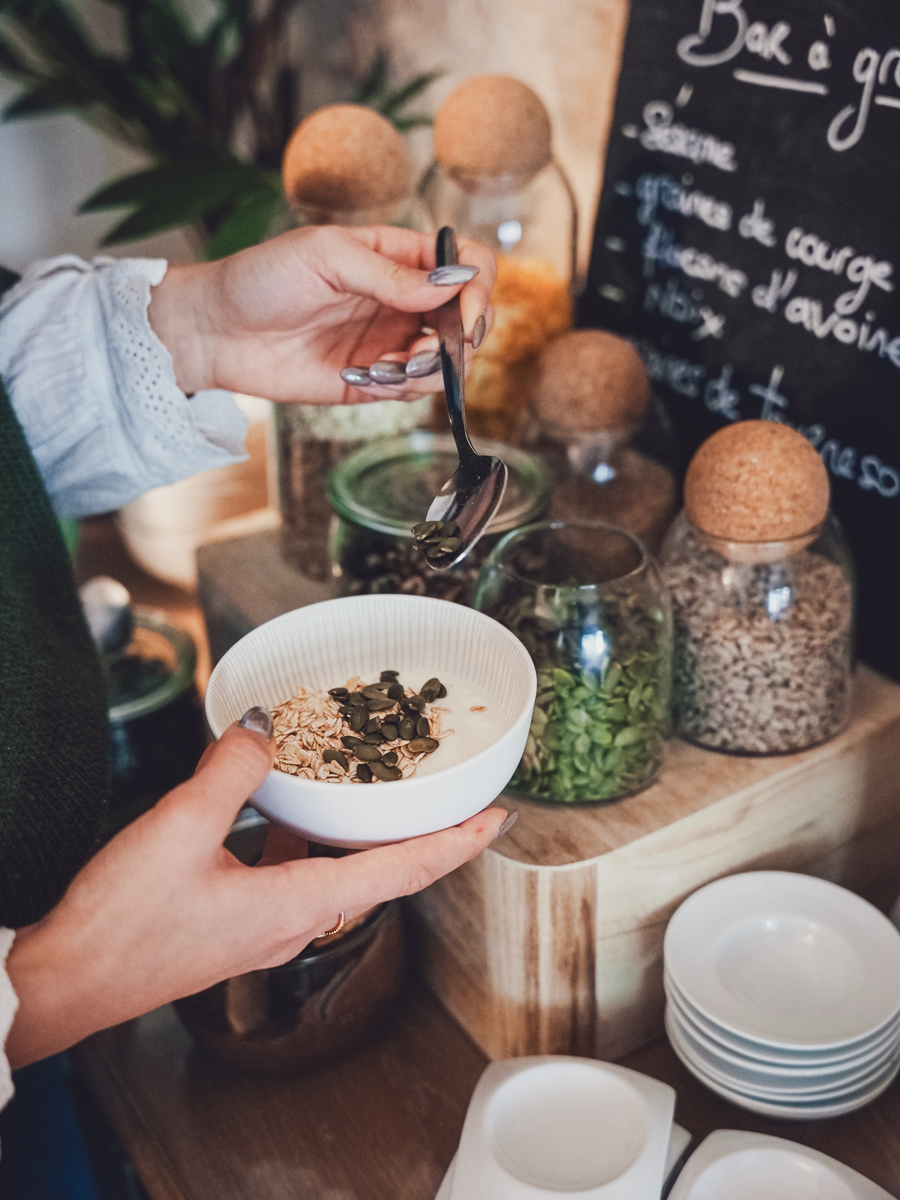 Cliente qui se sert des graines dans son fromage blanc à l'hôtel de la paix 2 étoiles proche du marché de La Rochelle