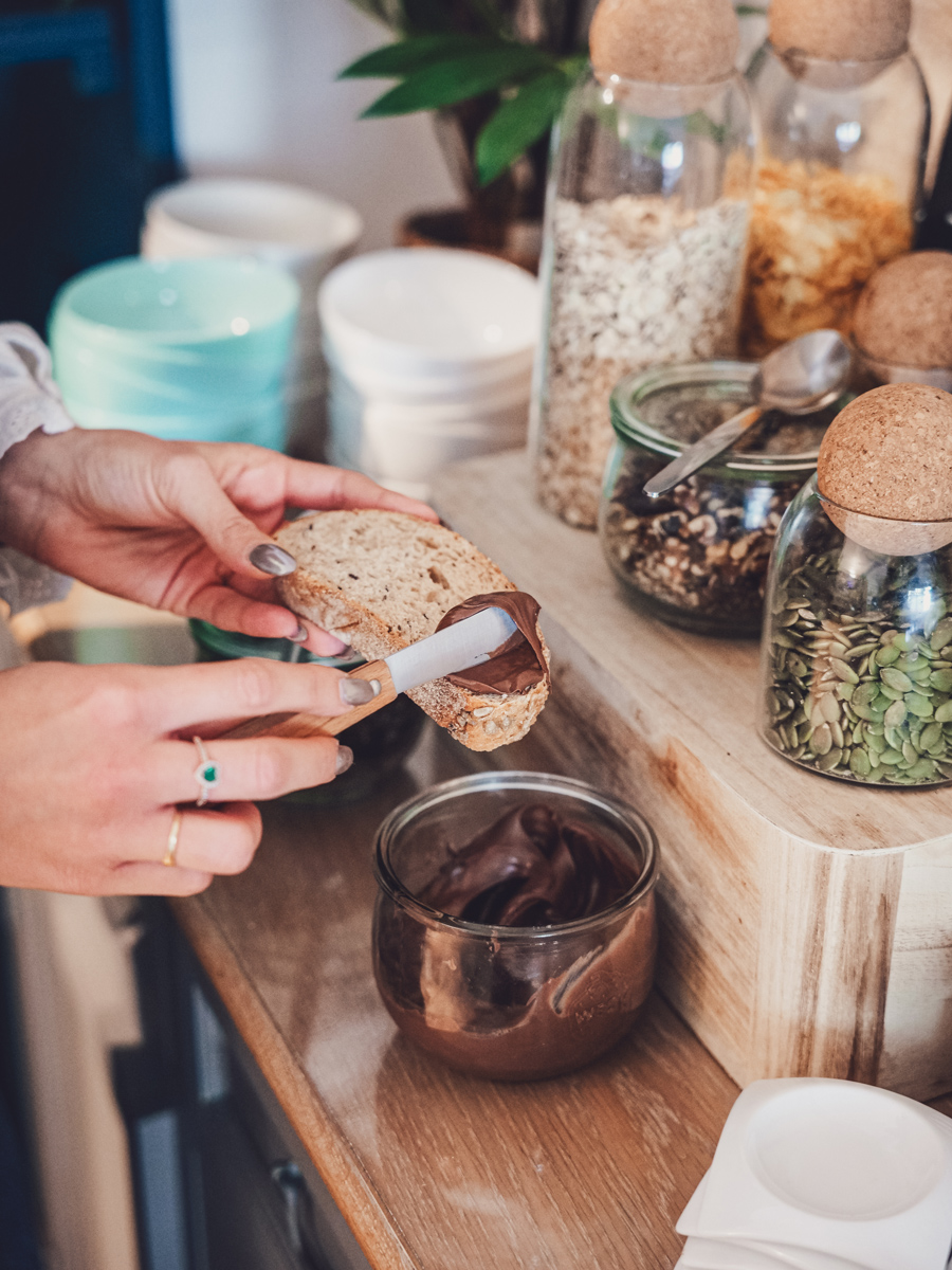 Cliente qui se fait une tartine avec de la pâte à tartiné